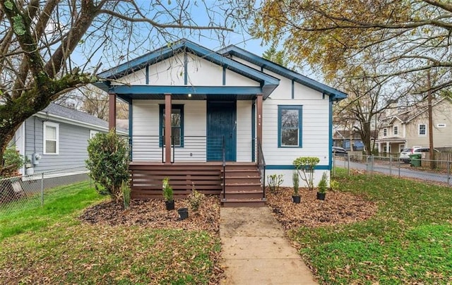 bungalow featuring a porch, a front yard, and fence