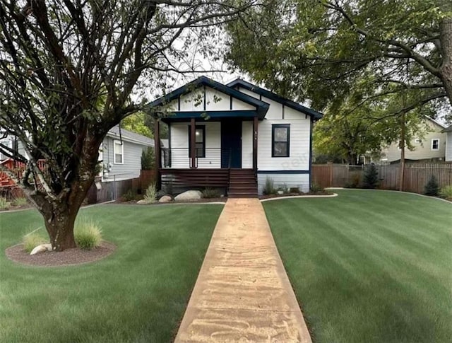 bungalow-style home featuring a front lawn and fence