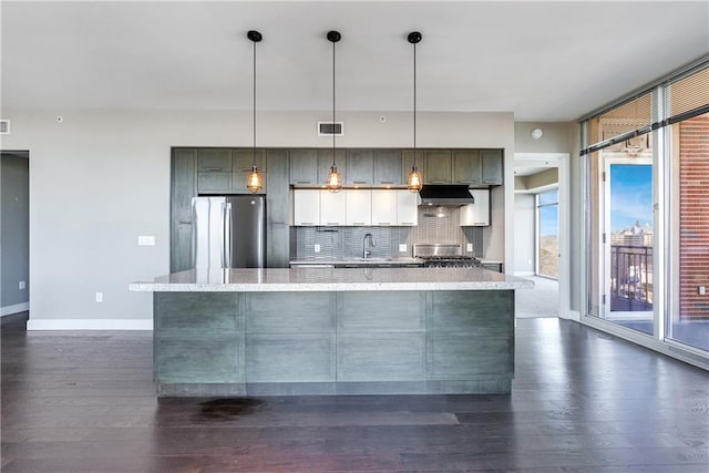 kitchen with dark wood finished floors, tasteful backsplash, visible vents, freestanding refrigerator, and a sink