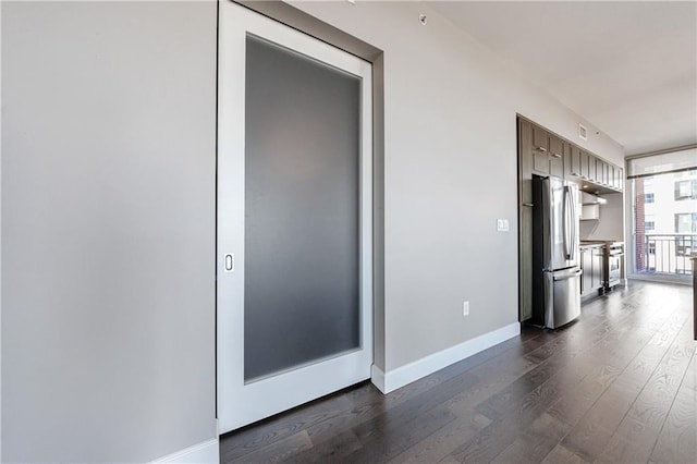 interior space featuring modern cabinets, baseboards, stainless steel appliances, and dark wood-style flooring