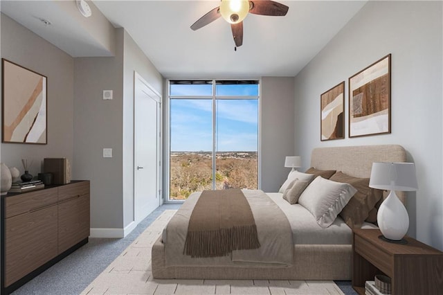 bedroom featuring baseboards, floor to ceiling windows, ceiling fan, and carpet flooring