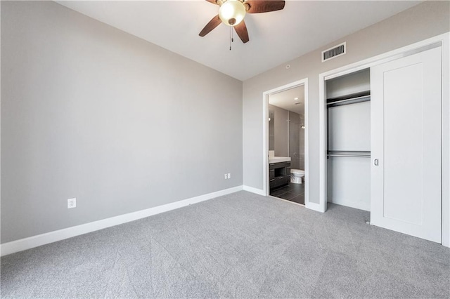 unfurnished bedroom featuring carpet, a closet, visible vents, ensuite bathroom, and baseboards