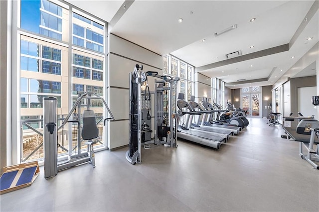 gym featuring floor to ceiling windows and recessed lighting