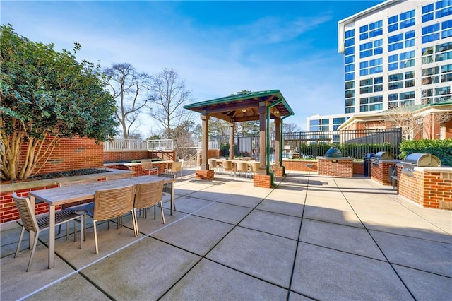 view of patio / terrace with grilling area, fence, outdoor dining area, and exterior kitchen