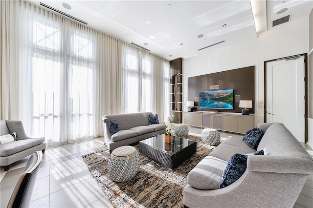 living room featuring a wealth of natural light, visible vents, and tile patterned floors