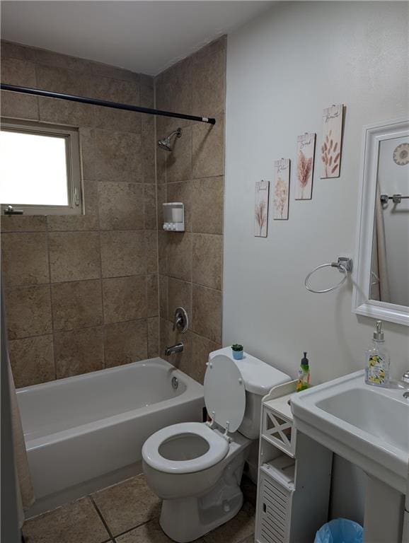 bathroom with tile patterned flooring, bathtub / shower combination, a sink, and toilet