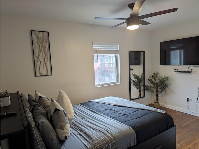 bedroom featuring ceiling fan, baseboards, and dark wood-style flooring