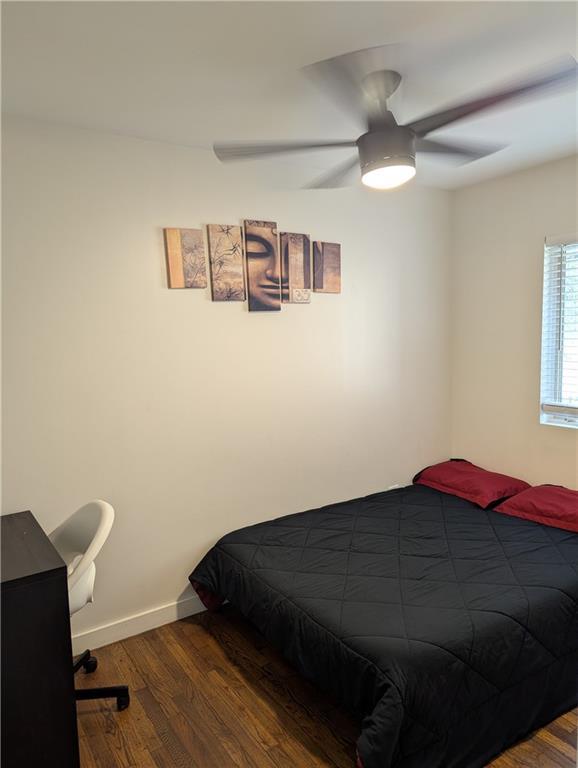 bedroom featuring dark wood-style floors, baseboards, and a ceiling fan