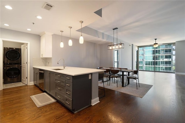 270 17th St NW Unit 2210, Atlanta, GA 30363 - kitchen featuring estacked washer and dryer, dishwasher, a peninsula, a sink, and white cabinets