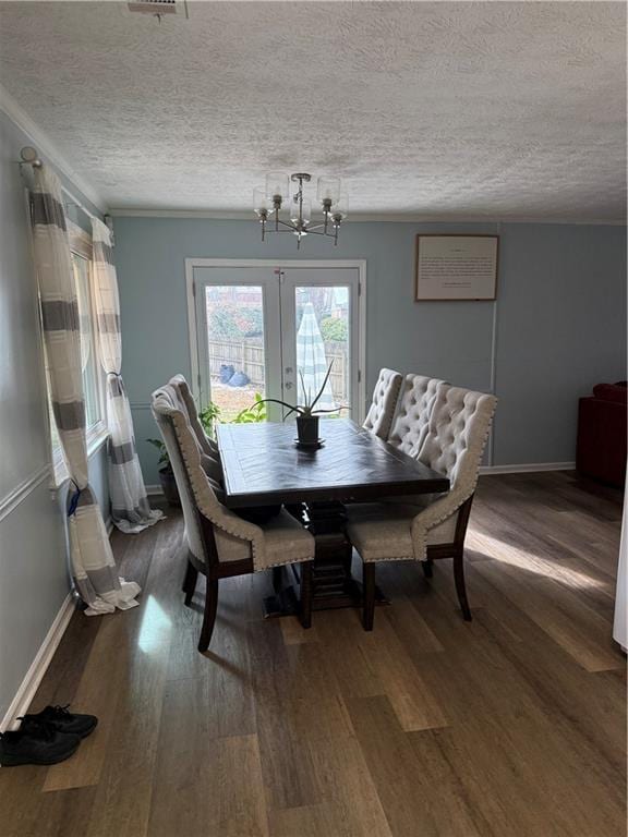 dining area with wood-type flooring, french doors, and a textured ceiling