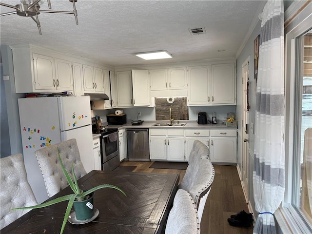 kitchen with sink, a textured ceiling, stainless steel appliances, and white cabinets