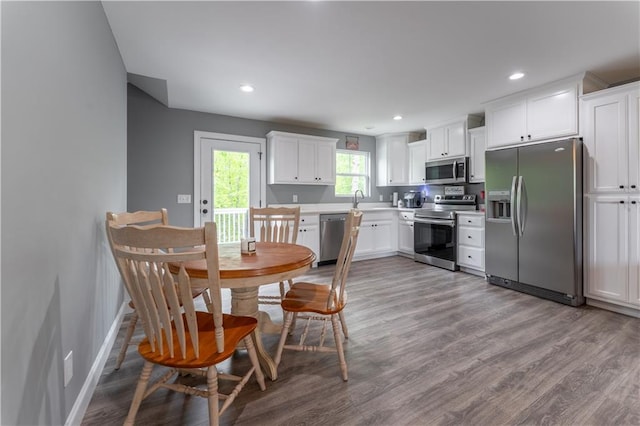 250 Silas Rd, Dahlonega, GA 30533 - kitchen featuring appliances with stainless steel finishes, a sink, white cabinets, wood finished floors, and recessed lighting