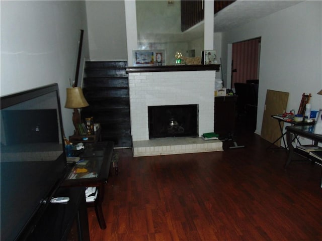 living room featuring hardwood / wood-style flooring and a brick fireplace