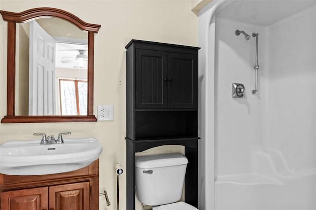 bathroom with a shower, vanity, and toilet