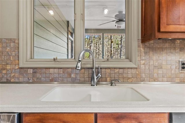 kitchen featuring brown cabinets, light countertops, and a sink