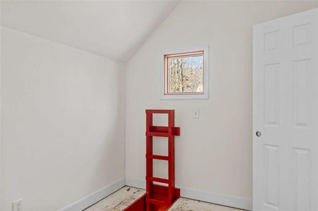 interior space featuring lofted ceiling and baseboards