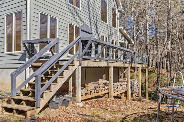 exterior space with a deck, a trampoline, and stairway