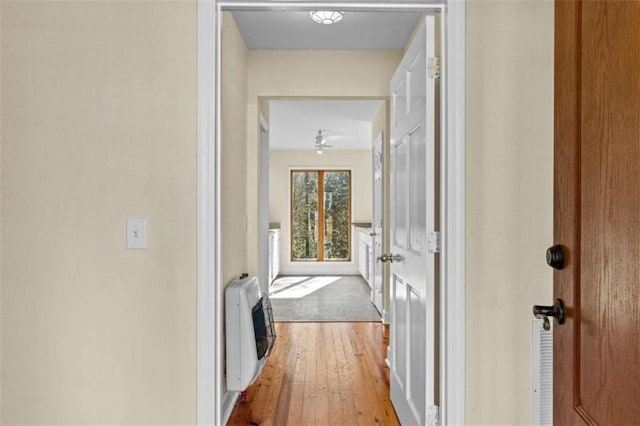 hallway featuring heating unit and wood finished floors