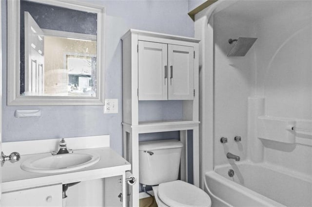 bathroom with toilet,  shower combination, and a sink