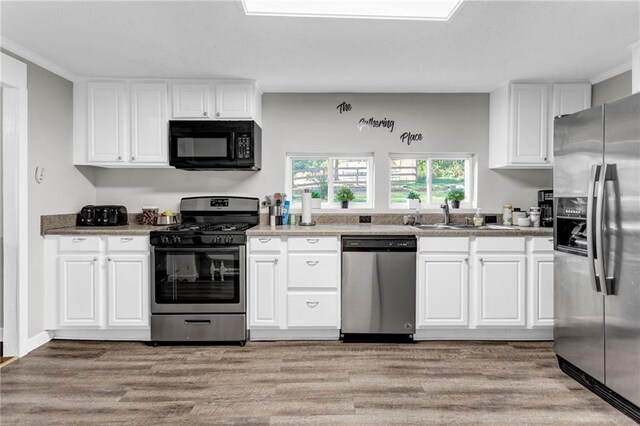 4481 Mclain Cir, Acworth, GA 30101 - kitchen featuring white cabinetry, a sink, light wood-style floors, and stainless steel appliances