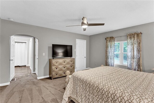 4481 Mclain Cir, Acworth, GA 30101 - carpeted bedroom featuring visible vents, ceiling fan, baseboards, arched walkways, and a textured ceiling