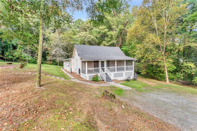 4481 Mclain Cir, Acworth, GA 30101 - view of front of property featuring a front yard, a porch, a wooded view, and driveway