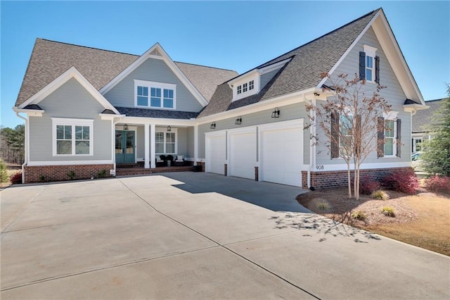 craftsman house featuring roof with shingles and concrete driveway