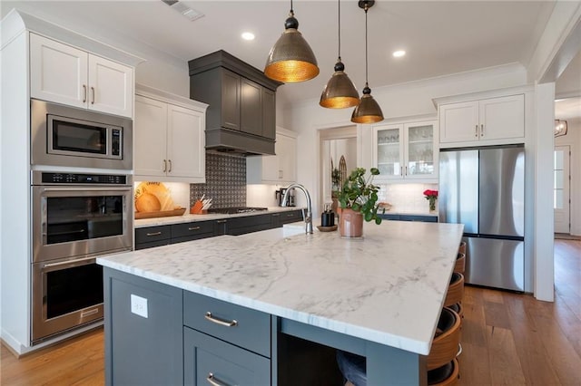 kitchen featuring visible vents, tasteful backsplash, appliances with stainless steel finishes, and light wood finished floors