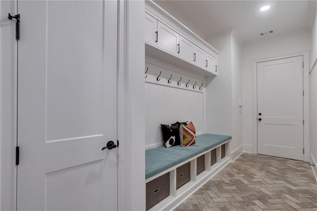 mudroom with visible vents, recessed lighting, and brick floor