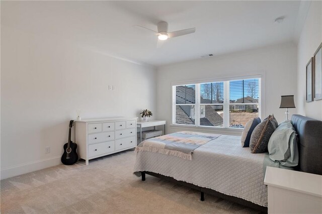 bedroom featuring visible vents, baseboards, light colored carpet, and a ceiling fan