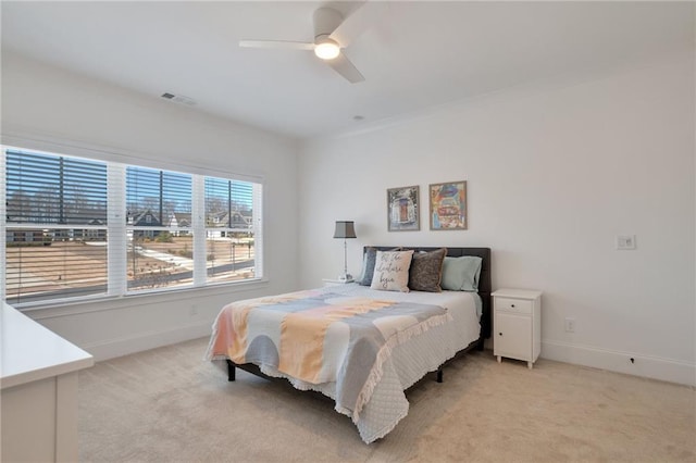 bedroom with light carpet, visible vents, a ceiling fan, and baseboards
