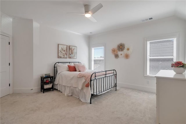bedroom featuring visible vents, light colored carpet, baseboards, and ceiling fan