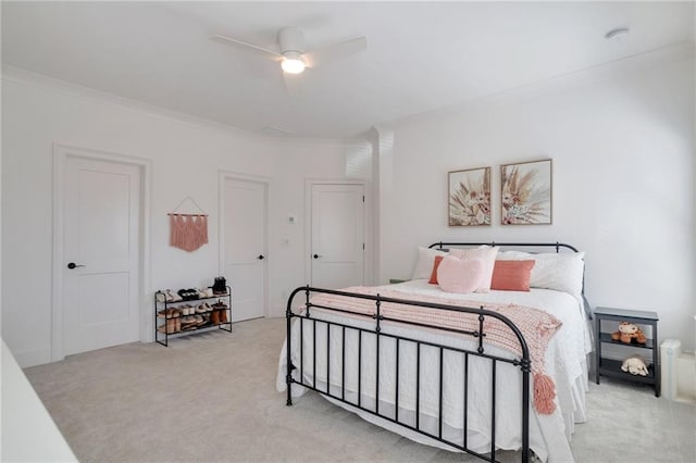 bedroom featuring a ceiling fan, crown molding, and light colored carpet