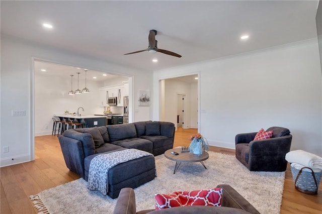 living room featuring light wood finished floors, recessed lighting, baseboards, and a ceiling fan