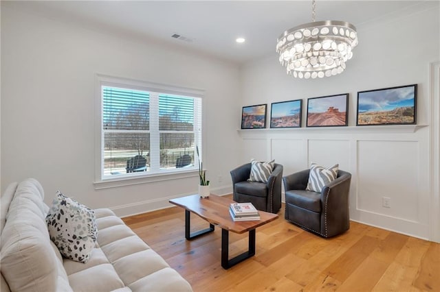 living area with visible vents, a chandelier, light wood-type flooring, recessed lighting, and a decorative wall