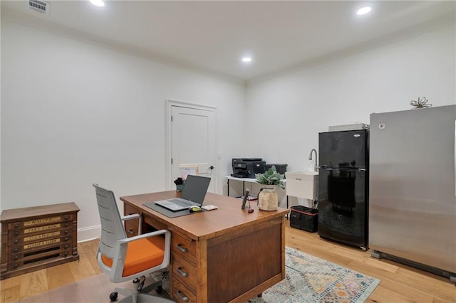 office featuring recessed lighting, visible vents, light wood finished floors, and a sink