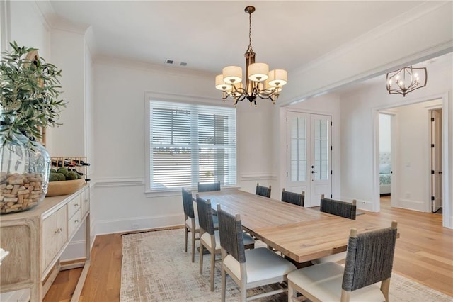 dining area featuring a chandelier, visible vents, and crown molding