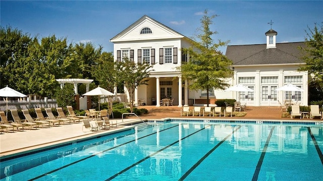 rear view of property with a community pool, a patio area, and french doors