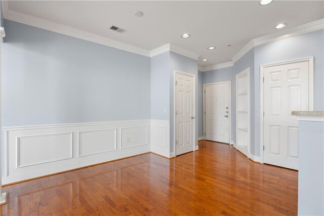 doorway with wood-type flooring and crown molding