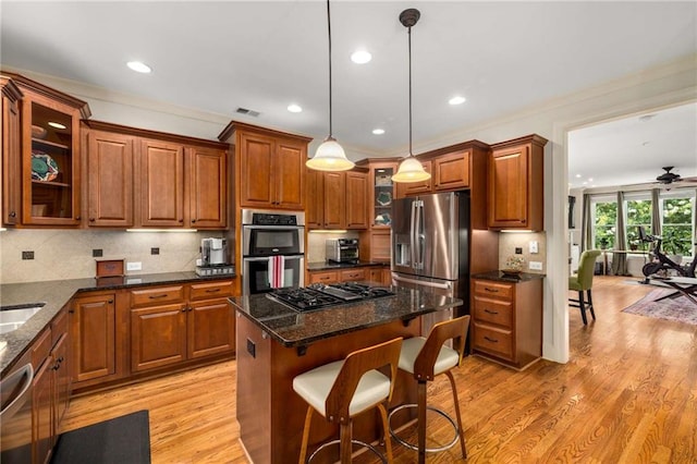 11271 Calypso Dr, Alpharetta, GA 30009 - kitchen featuring stainless steel appliances, brown cabinetry, light wood-style flooring, glass insert cabinets, and backsplash