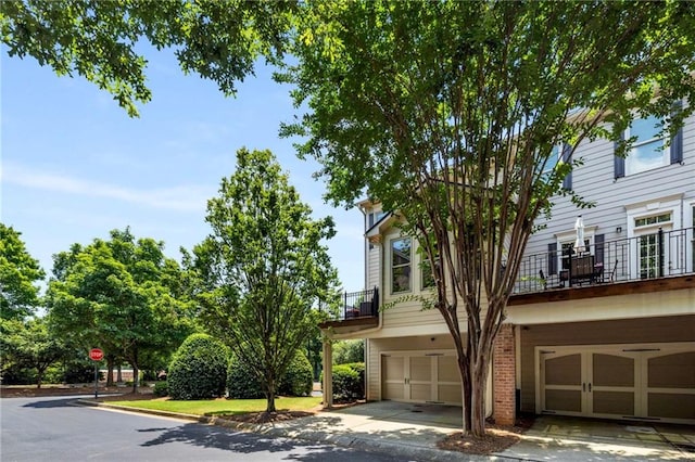 11271 Calypso Dr, Alpharetta, GA 30009 - view of front of house with an attached garage, brick siding, and a balcony