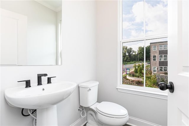 bathroom featuring baseboards and toilet