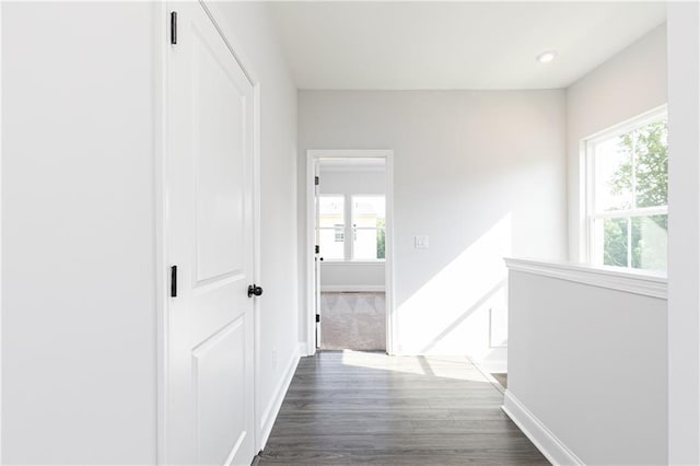 corridor featuring baseboards, dark wood finished floors, and recessed lighting