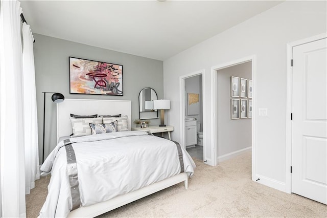 bedroom featuring light carpet, ensuite bath, and baseboards