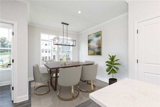 dining space featuring plenty of natural light, dark wood finished floors, crown molding, and baseboards