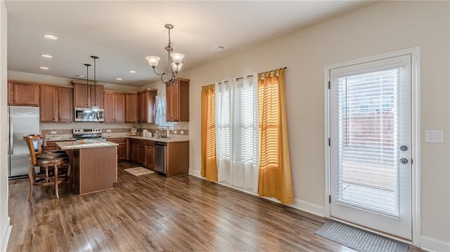 879 Tranquil Way, Hampton, GA 30228 - kitchen with appliances with stainless steel finishes, a chandelier, light countertops, a kitchen island, and dark wood-style floors