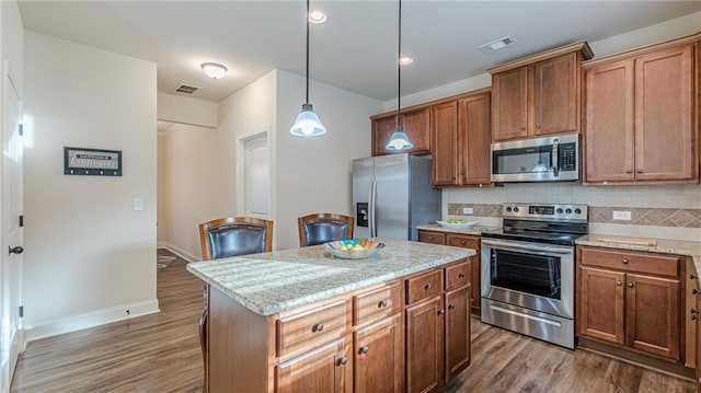 879 Tranquil Way, Hampton, GA 30228 - kitchen with stainless steel appliances, dark wood-style floors, decorative backsplash, hanging light fixtures, and a kitchen island