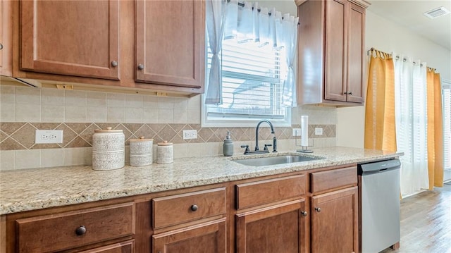 879 Tranquil Way, Hampton, GA 30228 - kitchen with dishwasher, backsplash, brown cabinetry, and light wood-type flooring