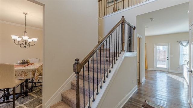 879 Tranquil Way, Hampton, GA 30228 - staircase featuring a chandelier, wood finished floors, and crown molding