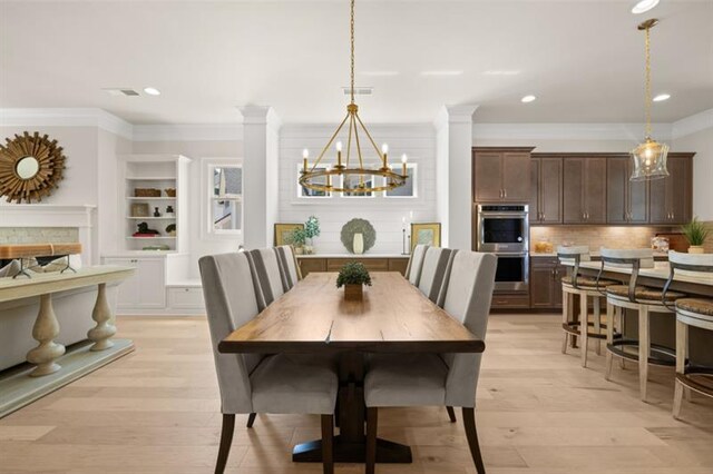 kitchen with sink, wall chimney exhaust hood, pendant lighting, dark brown cabinets, and a center island with sink